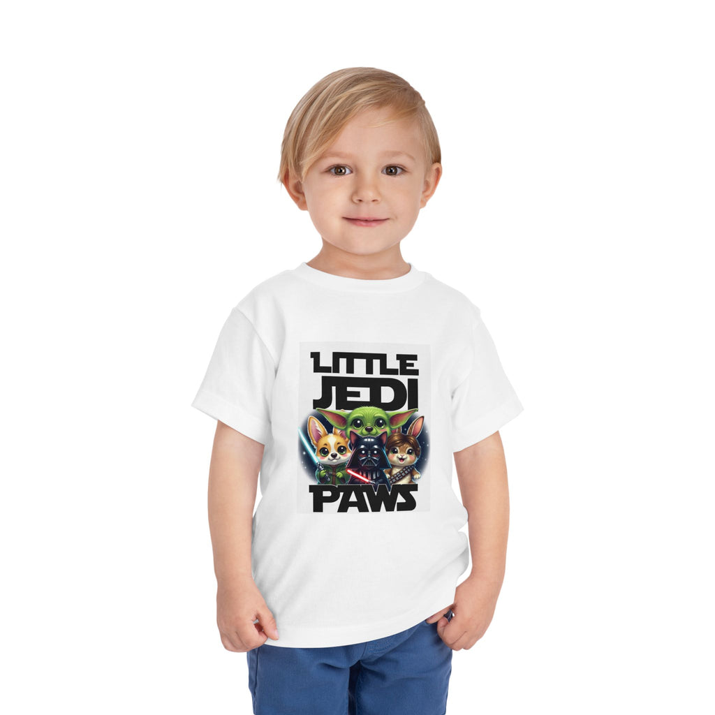 Toddler wearing a white tee featuring Yoda, Vader, and Chewbacca with the text "Little Jedi Paws.