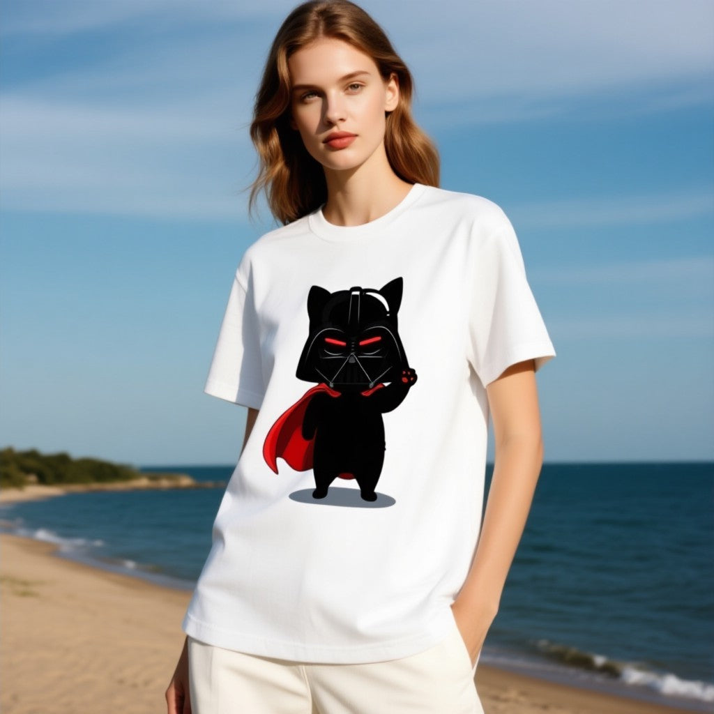 Darth Vader cat graphic t-shirt in white, featuring a black cat wearing a helmet and cape, standing on a beach.